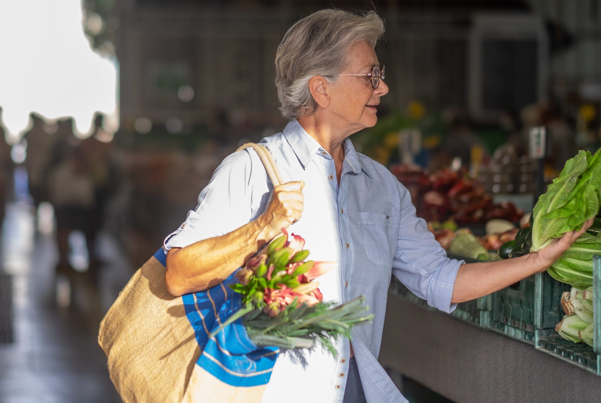Life Senior woman choosing fresh lettuce and vegetables at the green